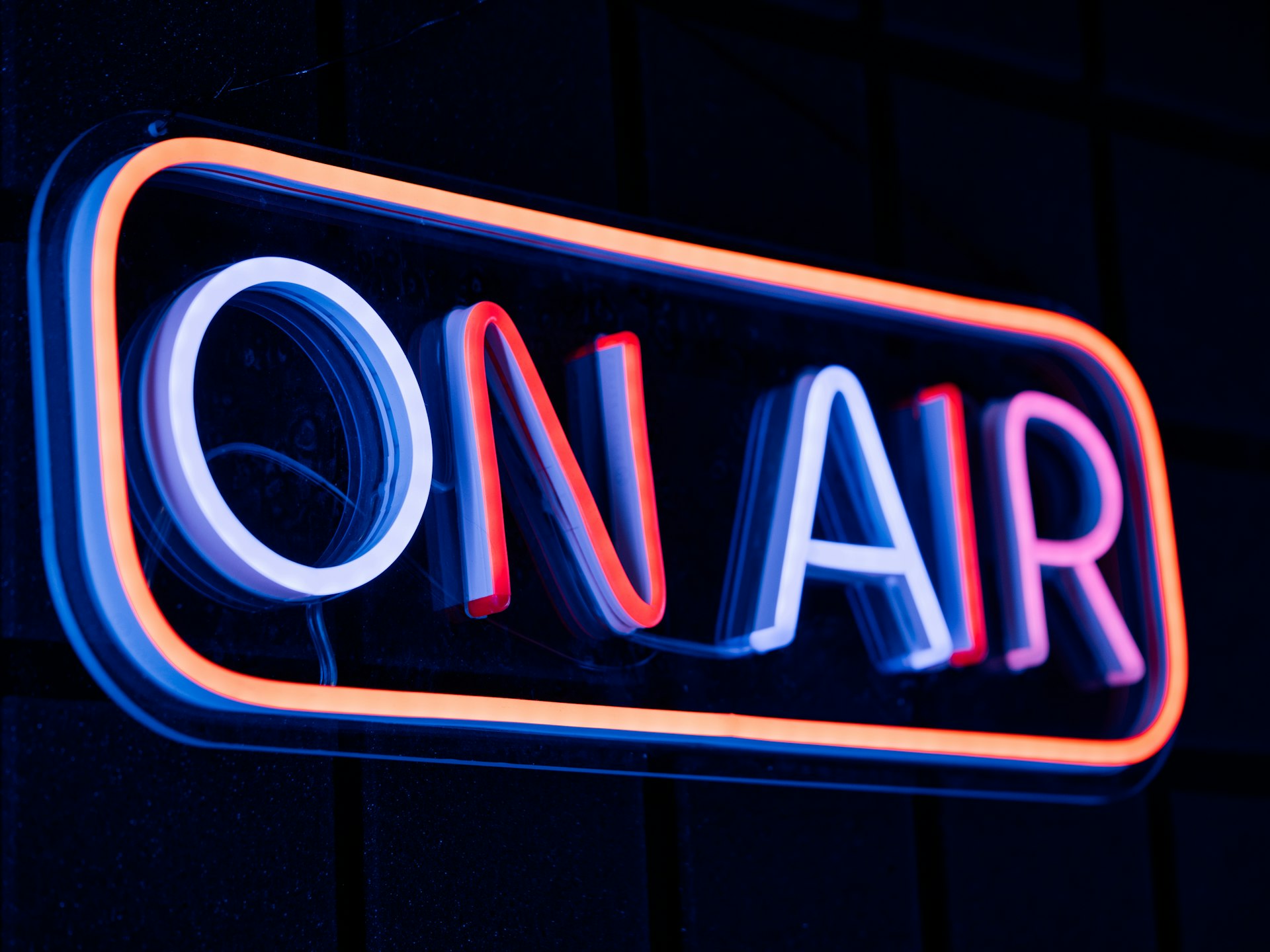 A neon sign indicates broadcasting is live.